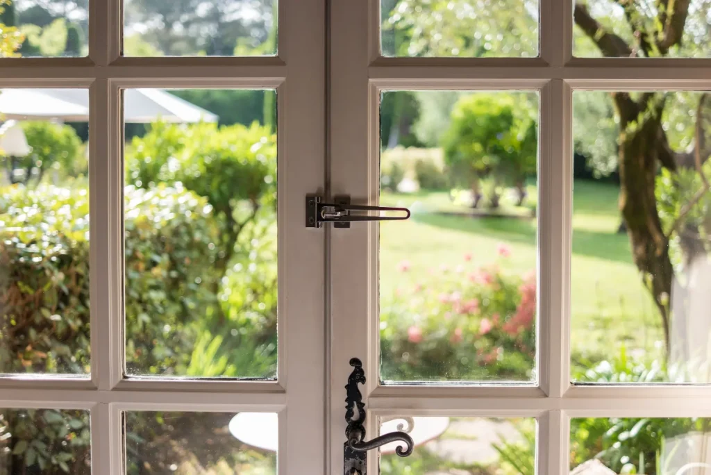 White French doors with decorative handles and garden view
